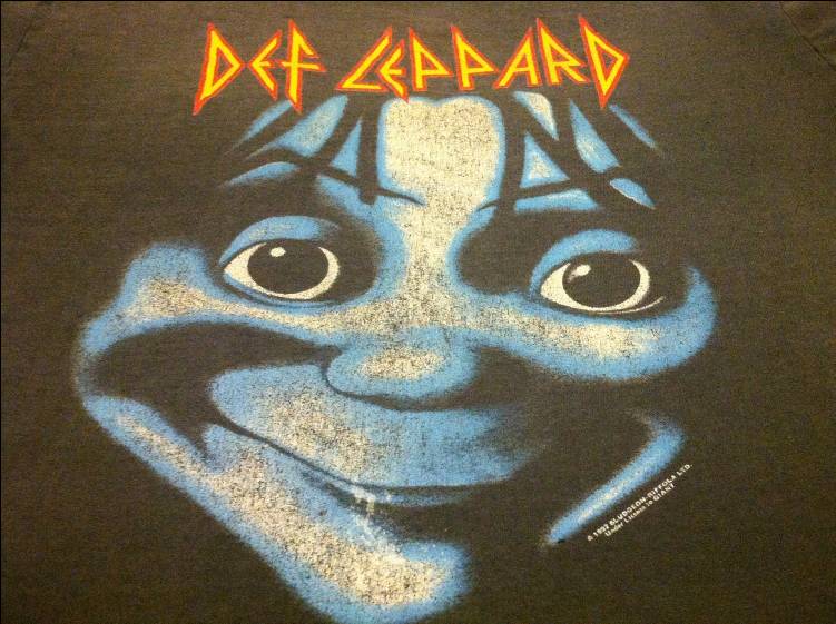 T-shirt with the Def Leppard Let's Get Rocked character's face grinning creepily.
