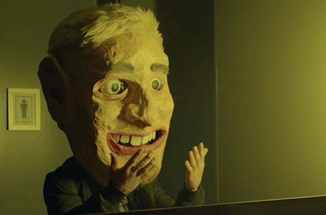 Man with a comically large paper mâché head, from Mike Posner's music video of I took a Pill in Ibiza.