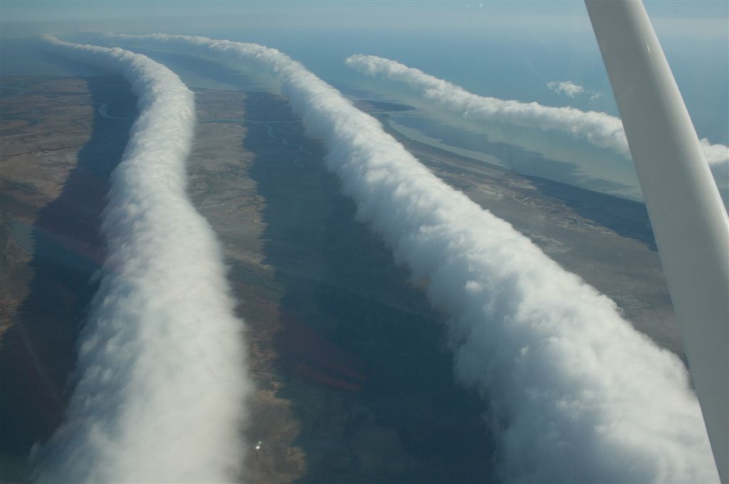Three narrow rolling bands of clouds viewed from the air.