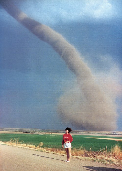 Woman in red shirt posing in front of a tornado.