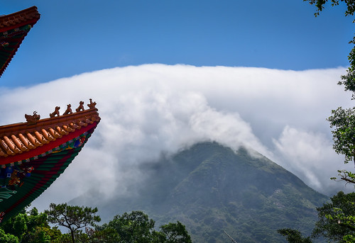 Part of a monastery roof with large cloud in the background.