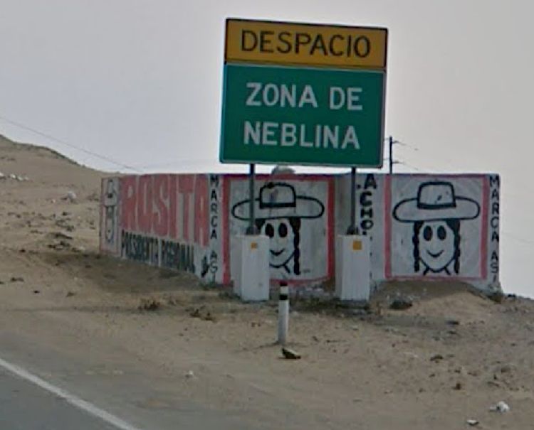 Sign that says Despacio: Zona de Neblina. Cartoon of a woman wearing a hat in the background.