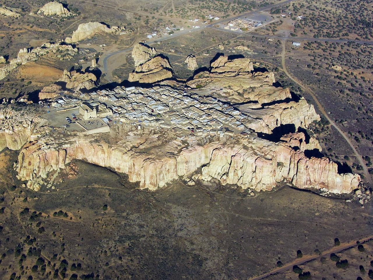 Aerial photo of Acoma Pueblo village on top of a prominent cliff.